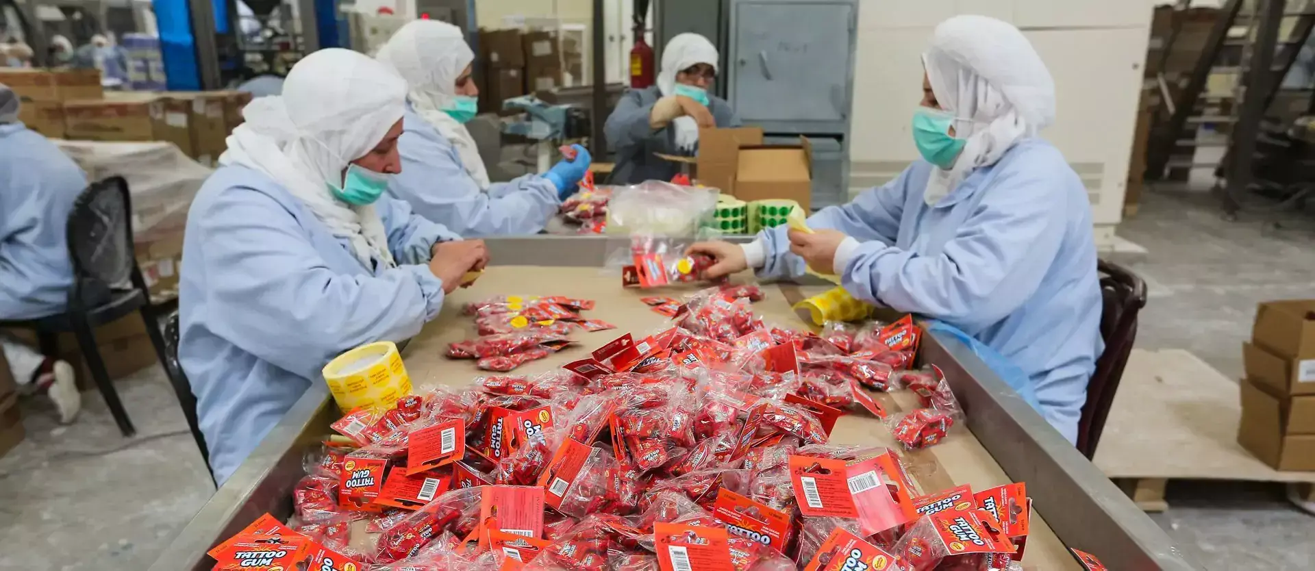 Chewing gums on the table in front of four women working at 'Maghreb Industries' factory